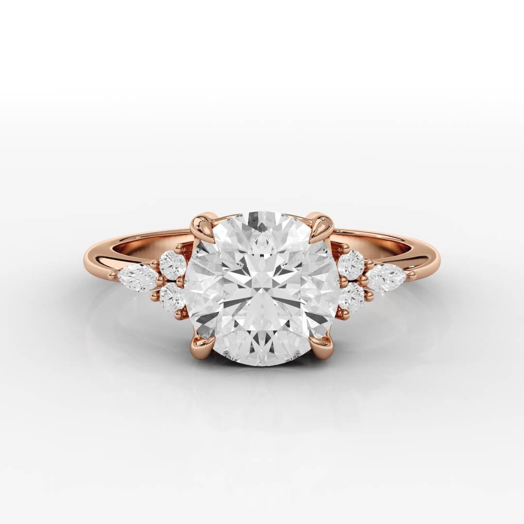 Rose gold ring with a large round center diamond flanked by smaller pear and round diamonds on each side.