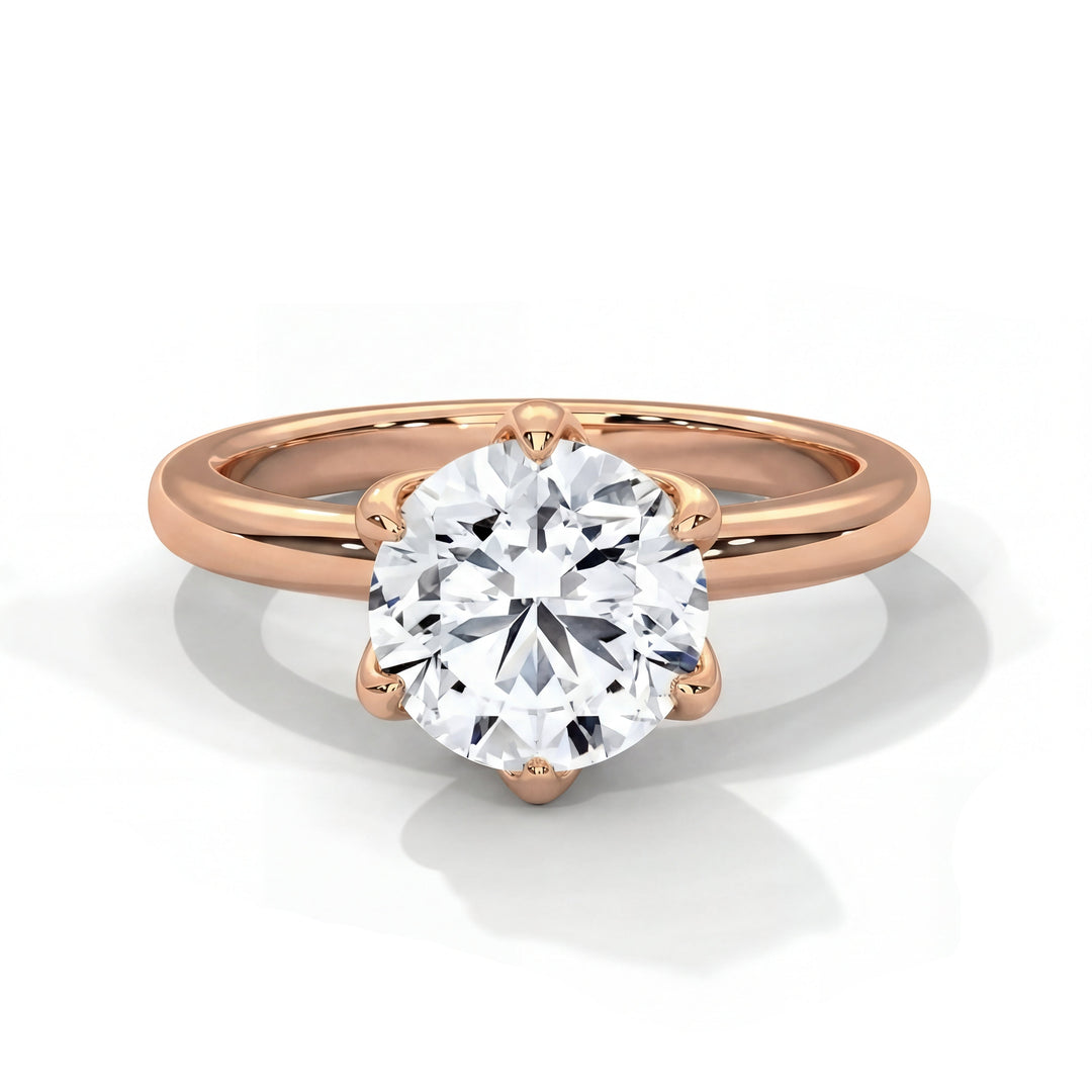 A rose gold ring with a round, sparkling diamond in a prong setting. The elegant simplicity of the design conveys a sense of timeless elegance.