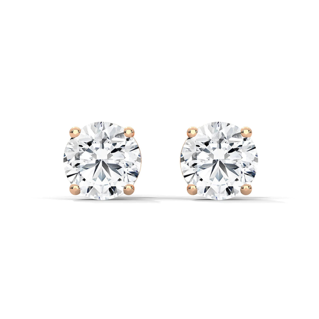 Round cut diamond stud earrings with rose gold settings on a white background.