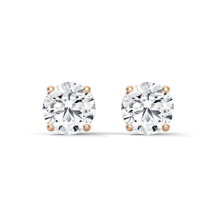 Round cut diamond stud earrings with rose gold settings on a white background.