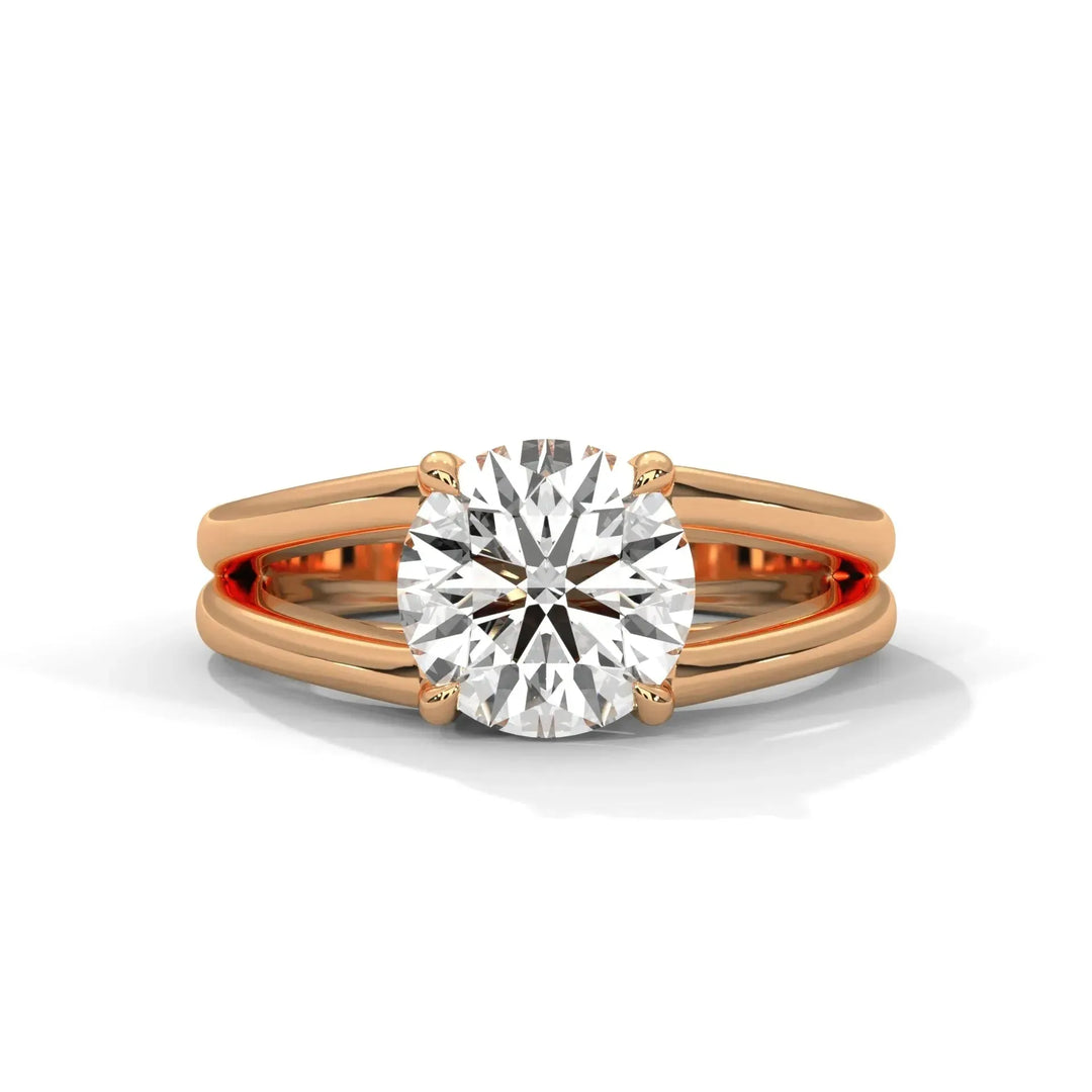 A round diamond solitaire is set on a sleek rose gold band, split to emphasize the stone's brilliance. The ring exudes elegance and modern sophistication.