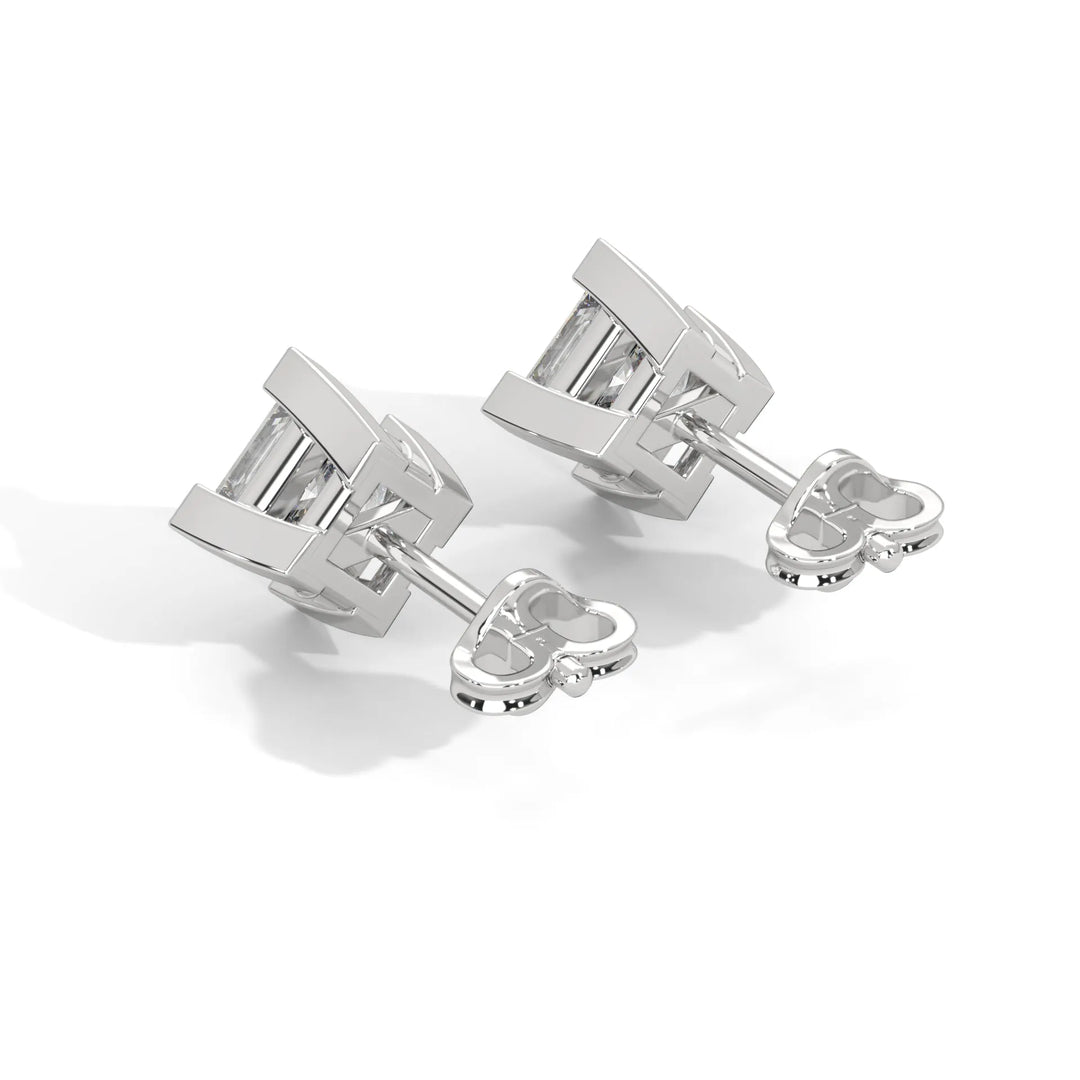 Silver cufflinks with a geometric design on a white background.