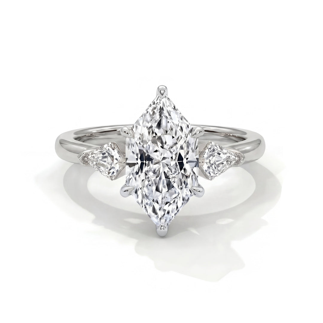 Silver ring with a central marquise-cut diamond and two smaller pear-shaped diamonds on each side, reflecting elegance and luxury against a white background.