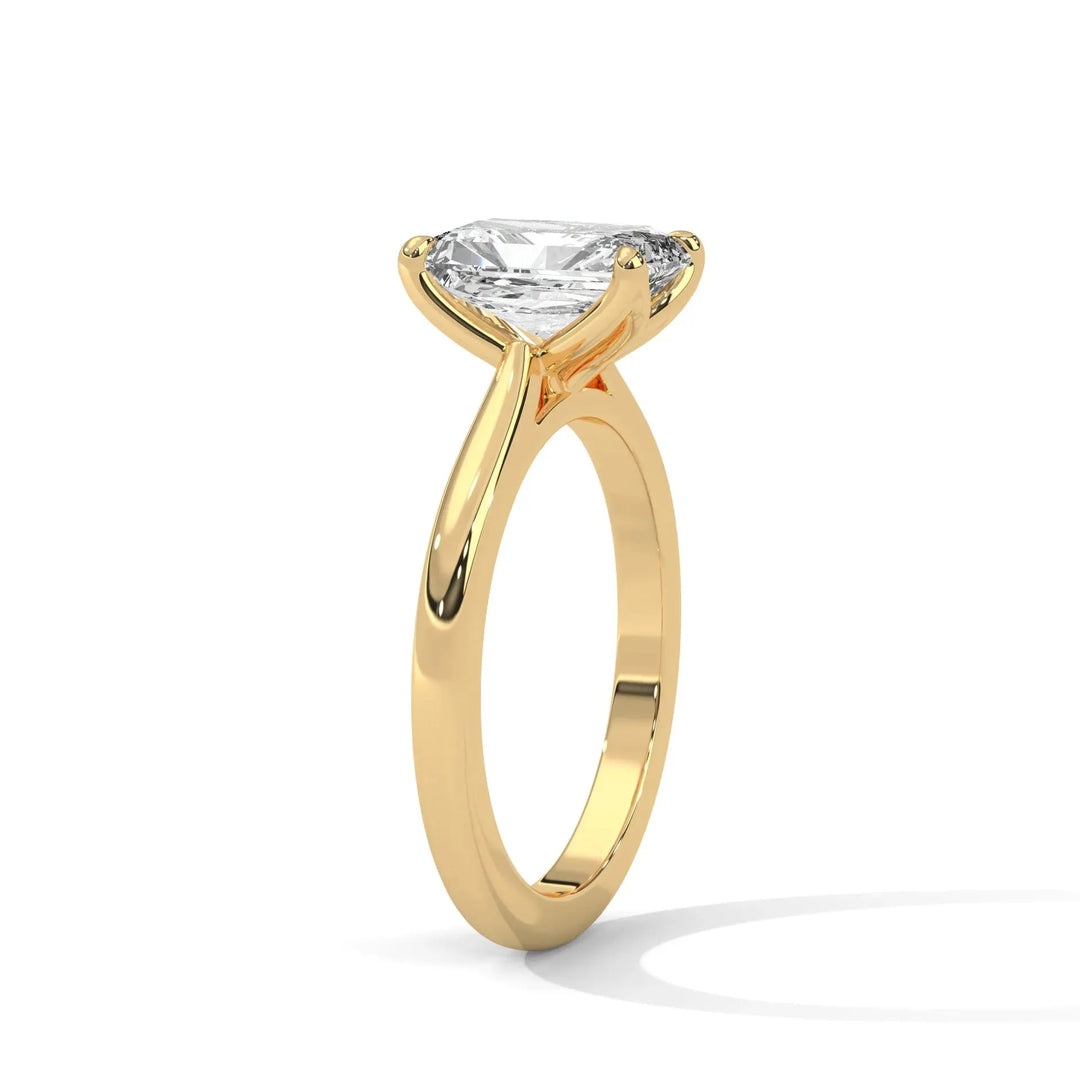 A sleek gold ring with a large, clear diamond solitaire set in a prong setting. The ring is elegantly curved, casting a faint shadow on a white background.