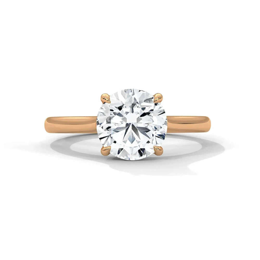 A solitaire engagement ring with a round, brilliant-cut diamond set in a four-prong rose gold band. The ring reflects elegance and simplicity.