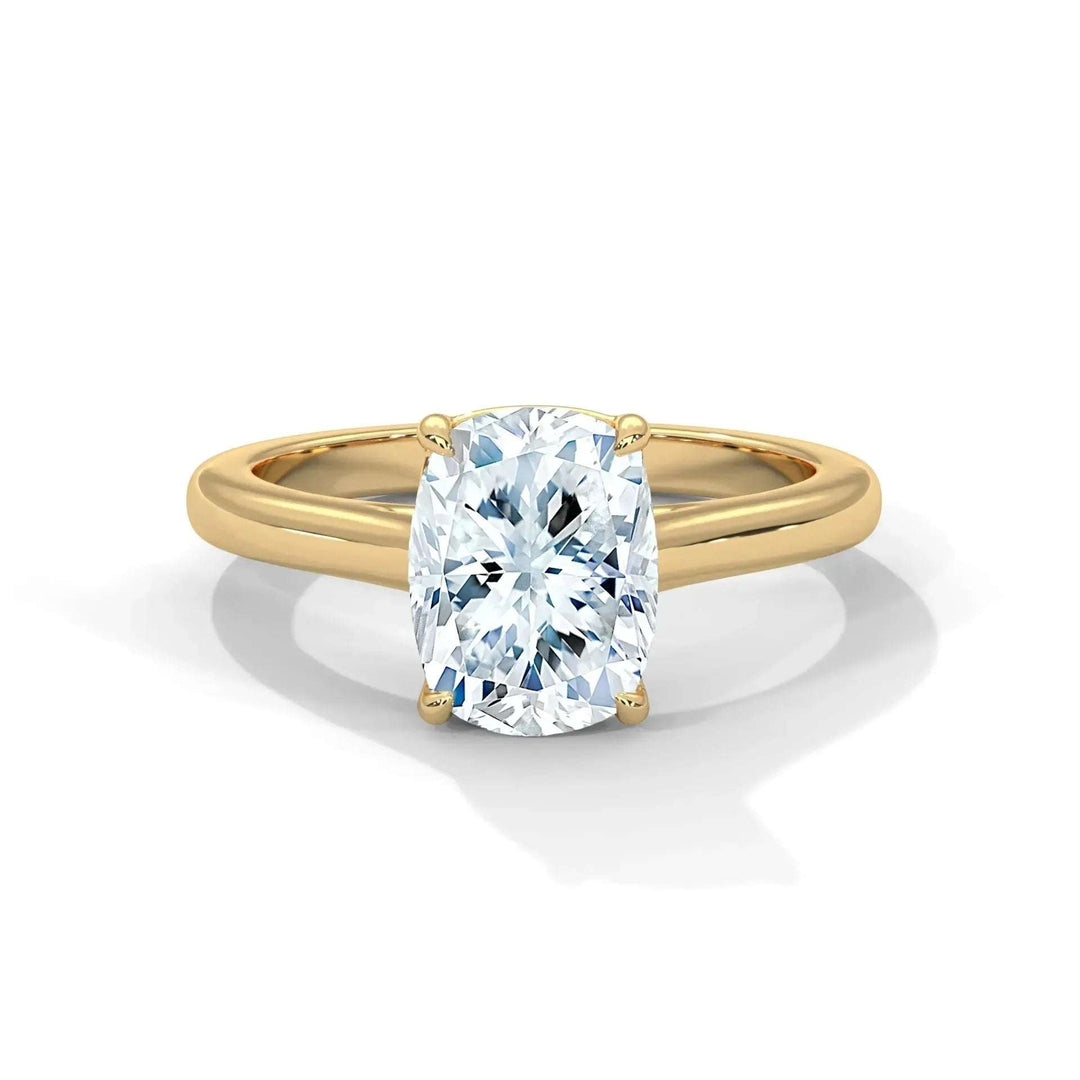 A sparkling cushion-cut diamond engagement ring set in a simple gold band with four prongs. The sleek design conveys elegance and sophistication.
