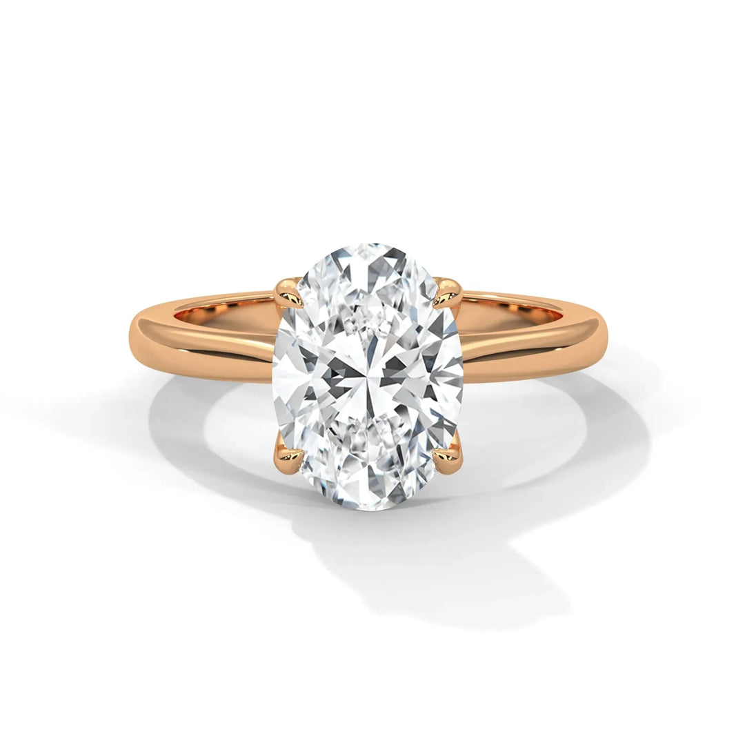 A sparkling, oval-cut diamond engagement ring with a rose gold band is displayed, exuding elegance and luxury against a plain white background.
