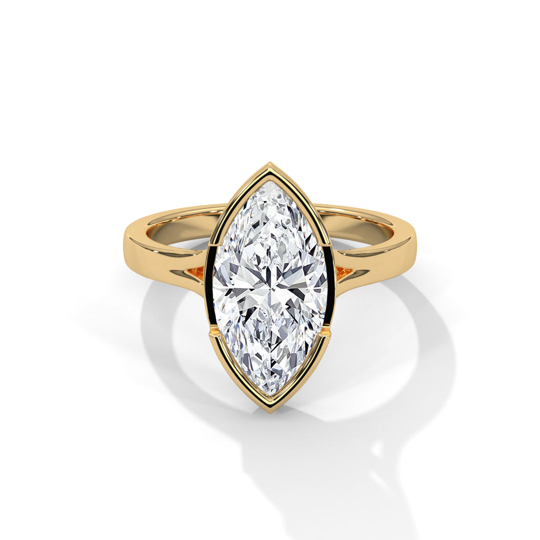 A marquise-cut diamond ring with a brilliant, elongated shape set in a sleek gold band, casting a soft shadow on a white surface, exuding elegance.