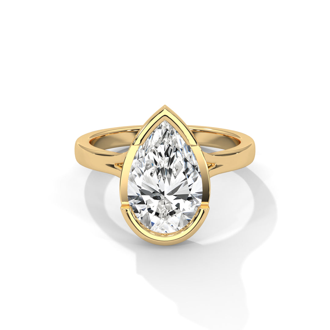 A pear-shaped diamond set in a sleek gold band, creating an elegant and luxurious ring design. The diamond's facets sparkle, enhancing its brilliance.