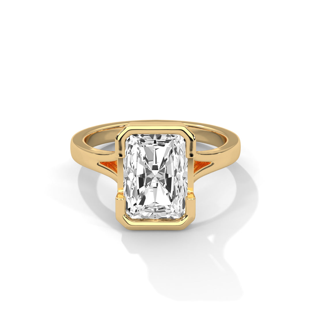 Gold ring with a radiant-cut diamond in a wide bezel setting, casting soft shadows on a white background. Elegant and luxurious design.