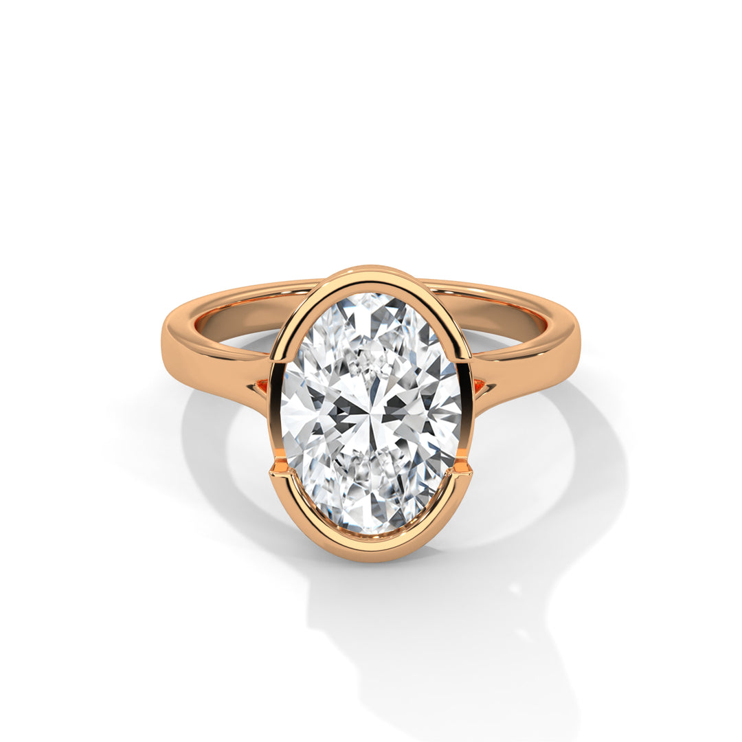A gold ring with an oval-cut diamond set in a sleek, modern design. The diamond sparkles brilliantly, reflecting light, creating an elegant and luxurious tone.